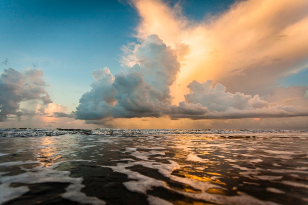 A seascape photograph of a sunrise over Surfside Beach, Texas, USA.